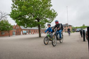 Børn cykler foran Hee Skole